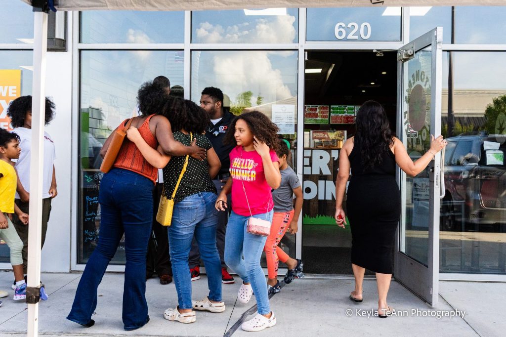 Locals arriving and hugging at the door of Stoner's Pizza Joint in Pooler for Throwback Pizza Night with Live Like Locals