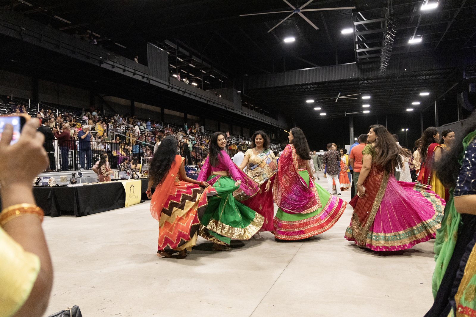 Garba dancers spin in a circle as the crowd watches at VyStar Pavilion, Port Wentworth